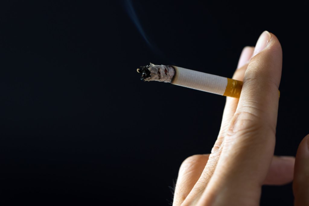 Hand holding cigarette, smoking