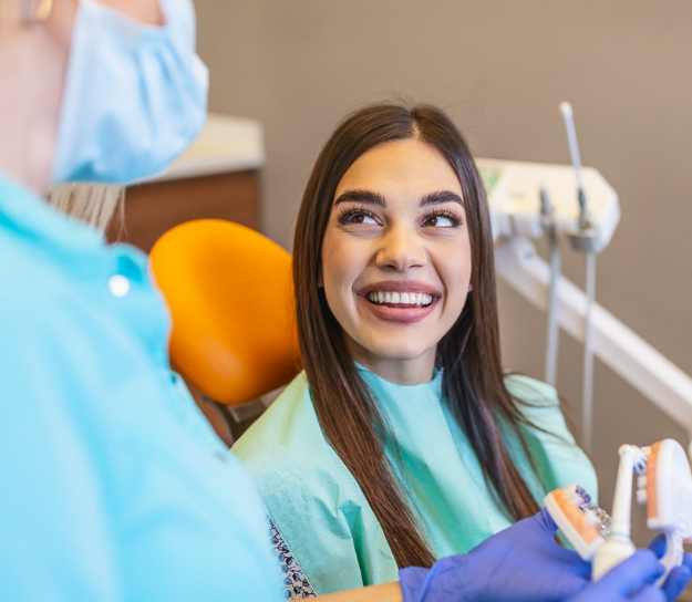 Young woman learning aftercare with dentist