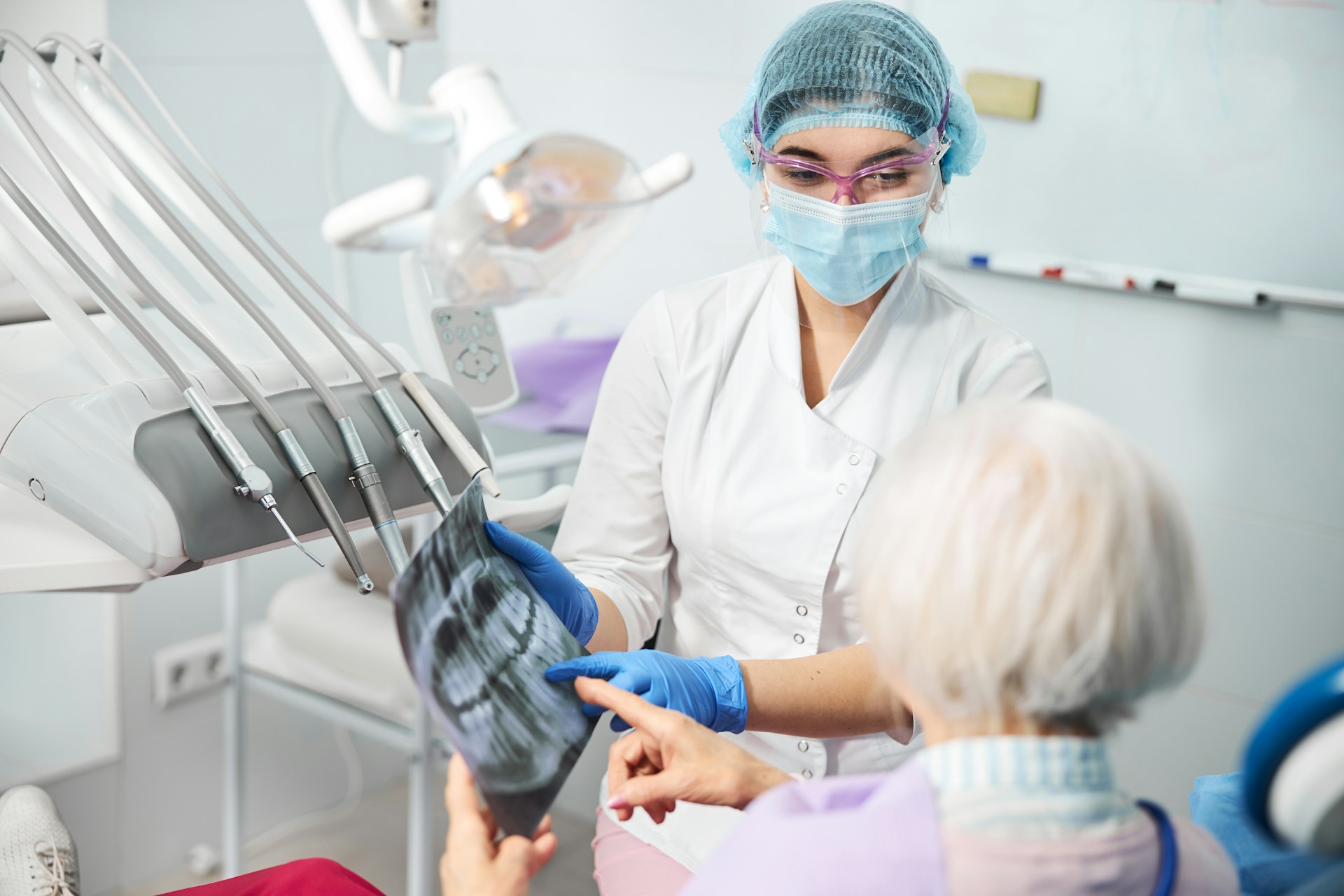 dentist assistant showing x-ray results to patient