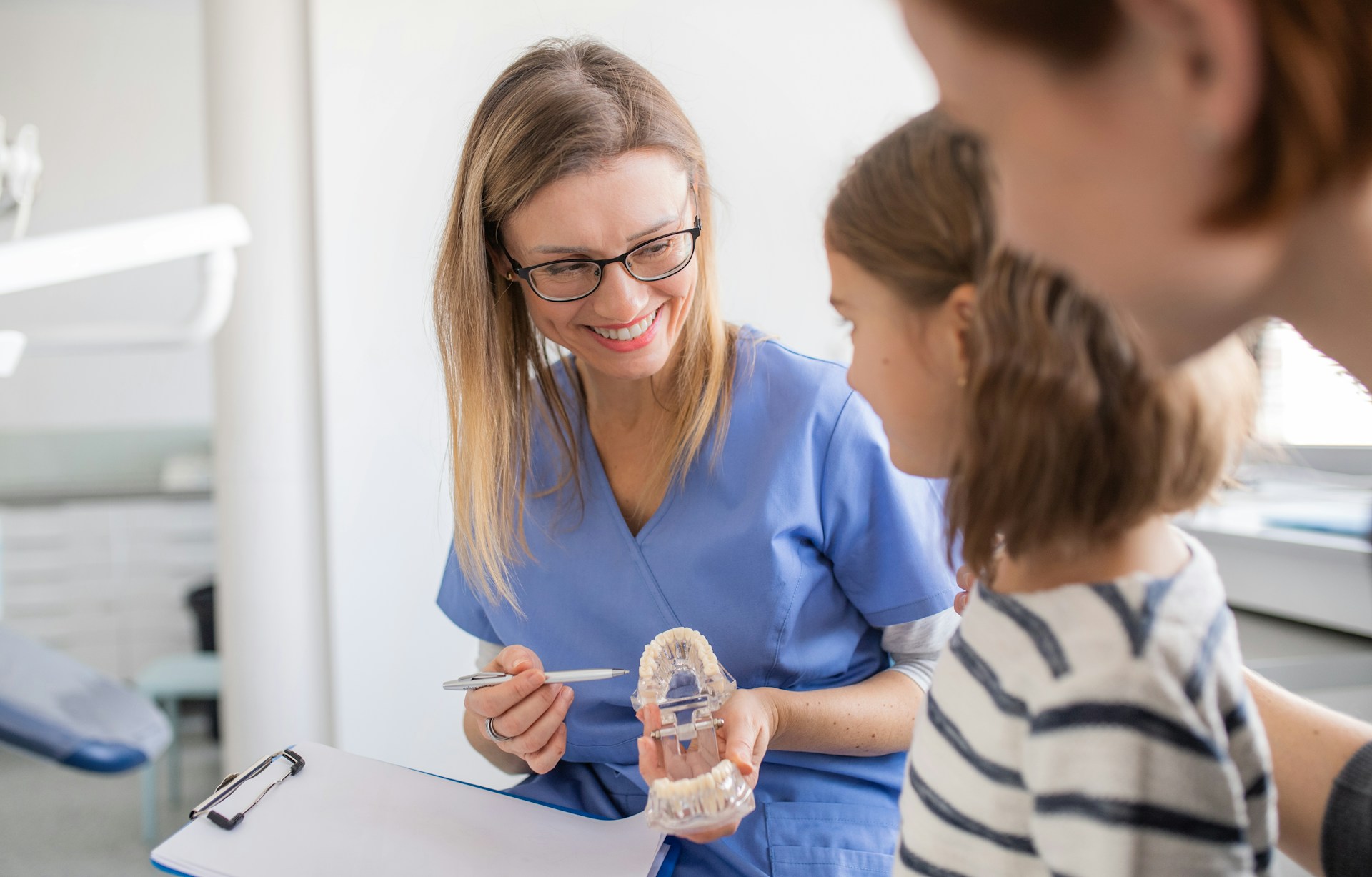 Dentist explaining tooth care to young patient