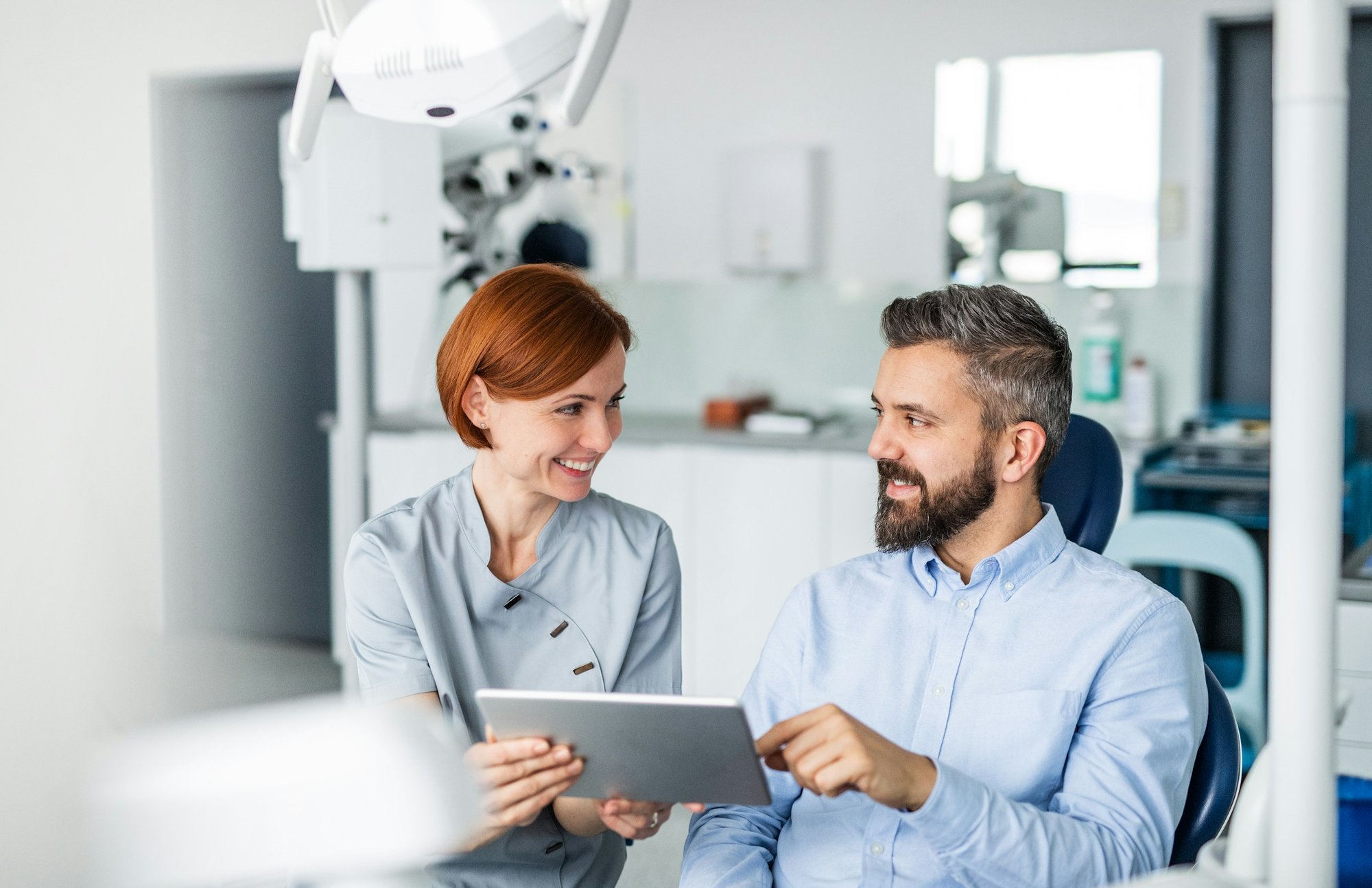 dental assistan reviewing patient's file with patient