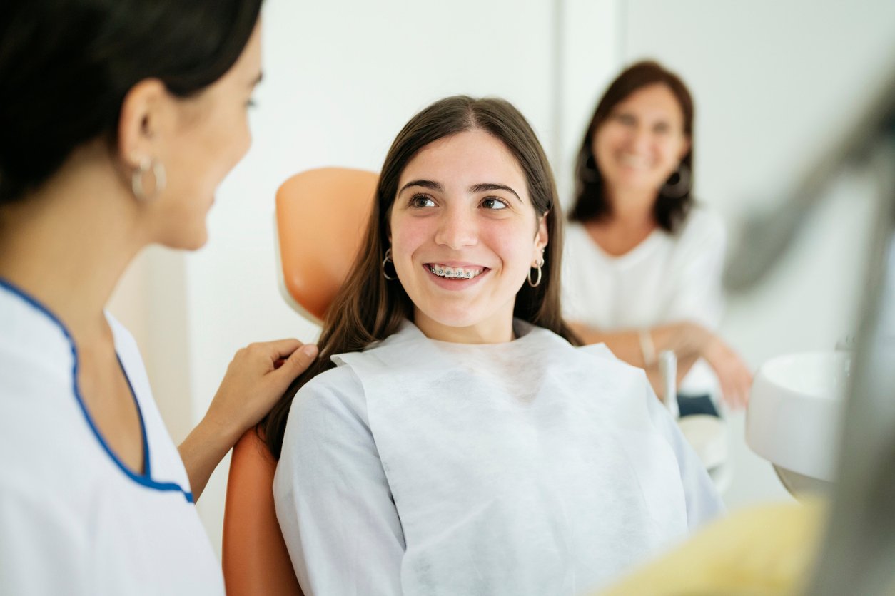Teen with braces at the dentist smiling