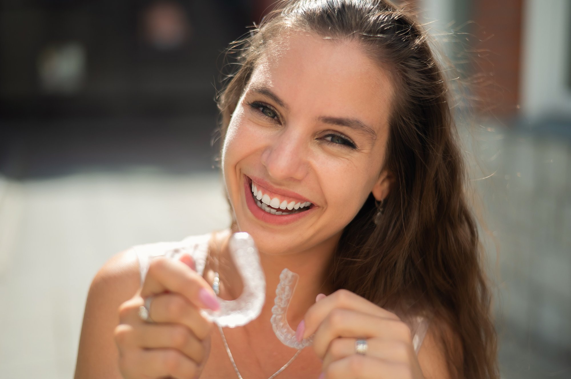 Woman smiling while wearing Invisalign clear aligners