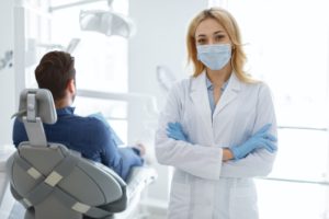 Female dentist in protective face mask posing at dental clinic